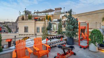 Una terraza en la azotea con mobiliario exterior, una exposición de bolas de nieve y vistas a la ciudad.