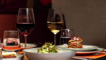Una mesa de comedor con diversos platos y copas de vino.