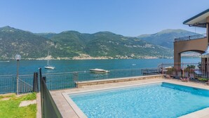 A swimming pool with a view of the sea and mountains.