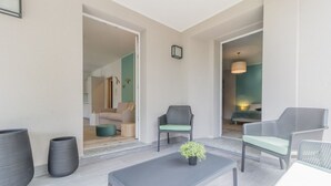 A modern living room with a grey sofa, a grey coffee table, and a small potted plant.