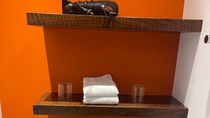 A bathroom with three wooden shelves, each holding folded towels and a pair of glasses. - Bright Studio Apartment in Konstanz (Konstanz)