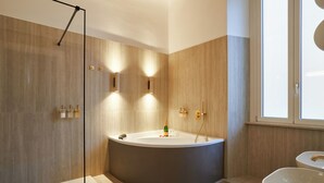 A modern bathroom with a large bathtub, a glass-enclosed shower, and a toilet. - Fantini Rooms- Fori Imperiali (Rome)