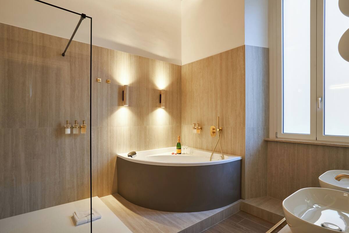 A modern bathroom with a large bathtub, a glass-enclosed shower, and a toilet.