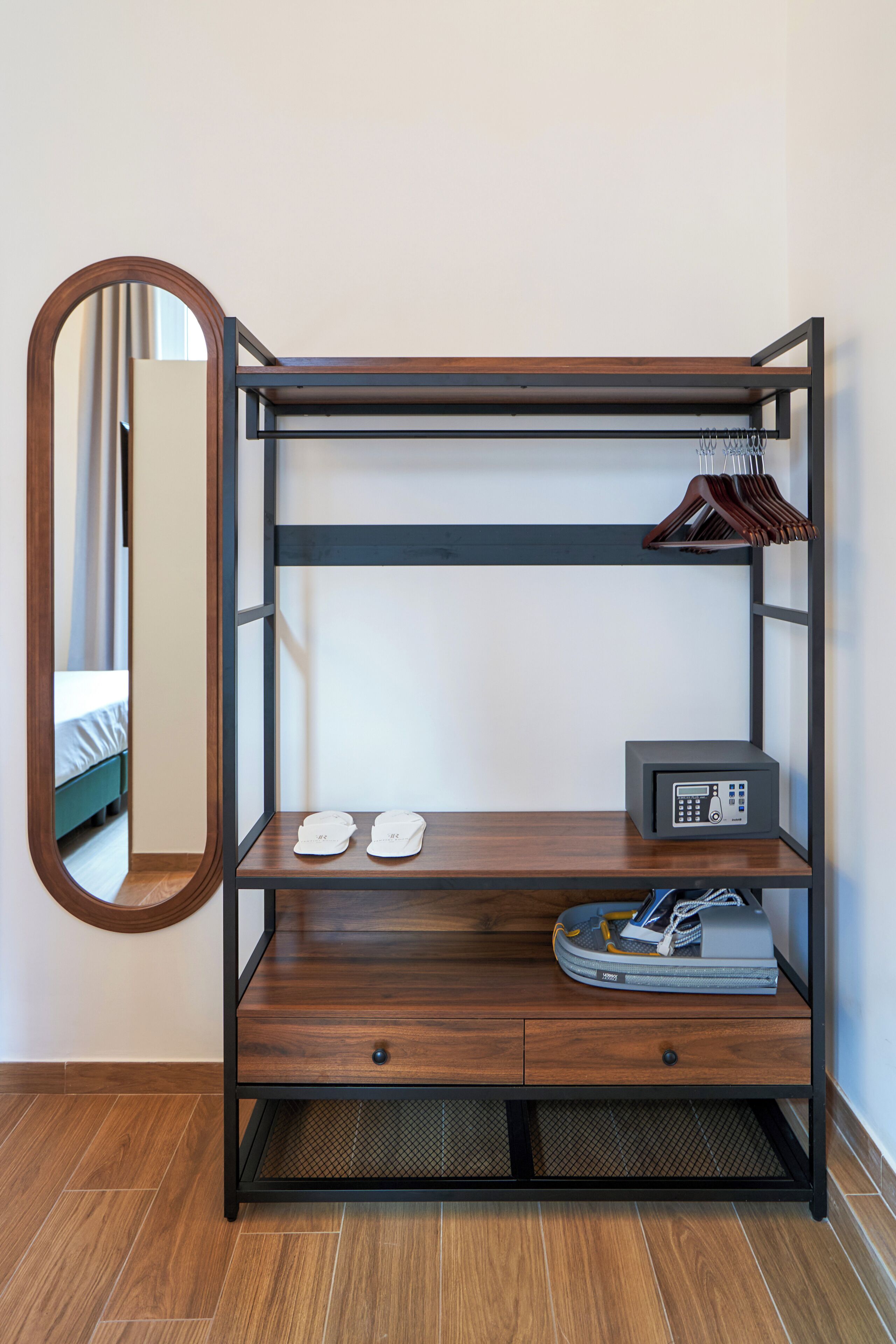 A bunk bed with a mirror, a shoe rack, and a radio on the lower shelf.