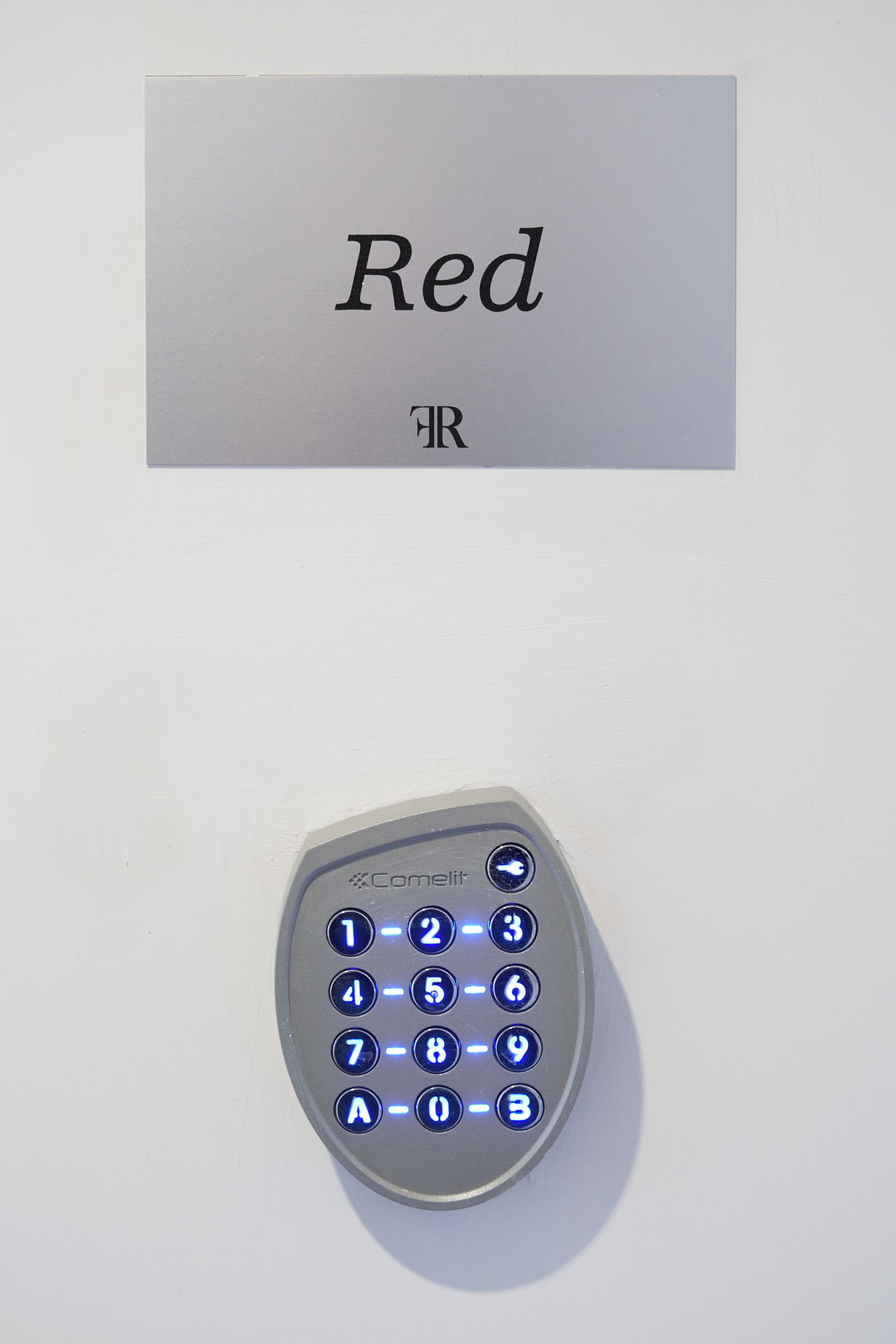 Et tastatur med oplyste tal og et skilt over, der siger 'Rød'.