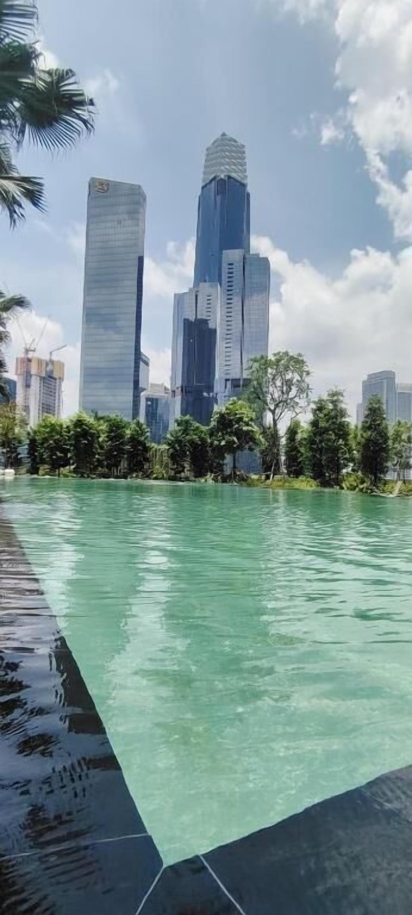 Ein Schwimmbecken mit Stadtansicht im Hintergrund.