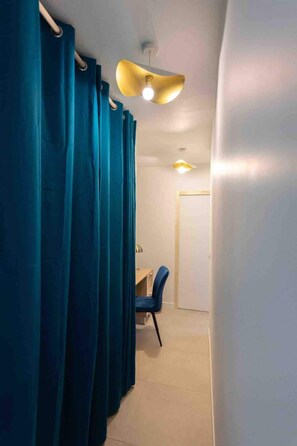 Una habitación con escritorio, silla y ventilador de techo.