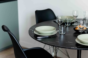 Una mesa de comedor preparada con platos, tazones, vasos y cubiertos.