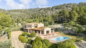 A two-story house with a swimming pool, surrounded by greenery and hills. - Country House 'Son Aladern' with Mountain View, Wi-Fi and Air Conditioning (Illes Balears)