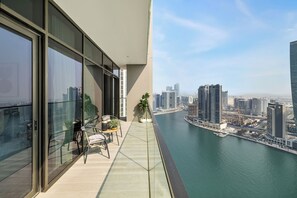 Ein Balkon mit Blick auf eine Stadtlandschaft und ein Gewässer.