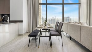 Un espace repas moderne avec une grande fenêtre, un canapé et un comptoir de cuisine.