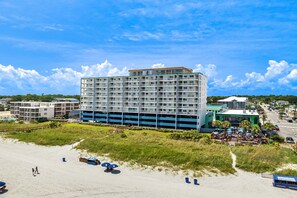 A multi-story hotel with a flat roof, located near a beach with a parking area and a restaurant. - 10% off 3-7 nights Oct- Dec. San A Bel 406 Cozy 2 bedroom 2 bath OF condo. (North Myrtle Beach)