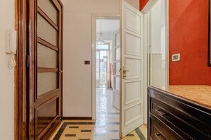 Ein Korridor mit einer Holztür, einer weißen Wand und einer roten Wand.
