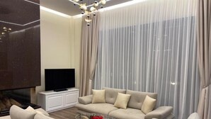 A modern living room with a sofa set, a coffee table, and a flat-screen TV. - Villas by Top Villas (Maminas)