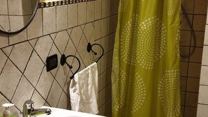 Ein Badezimmer mit Waschbecken, Spiegel und einer grünen Duschvorhang.