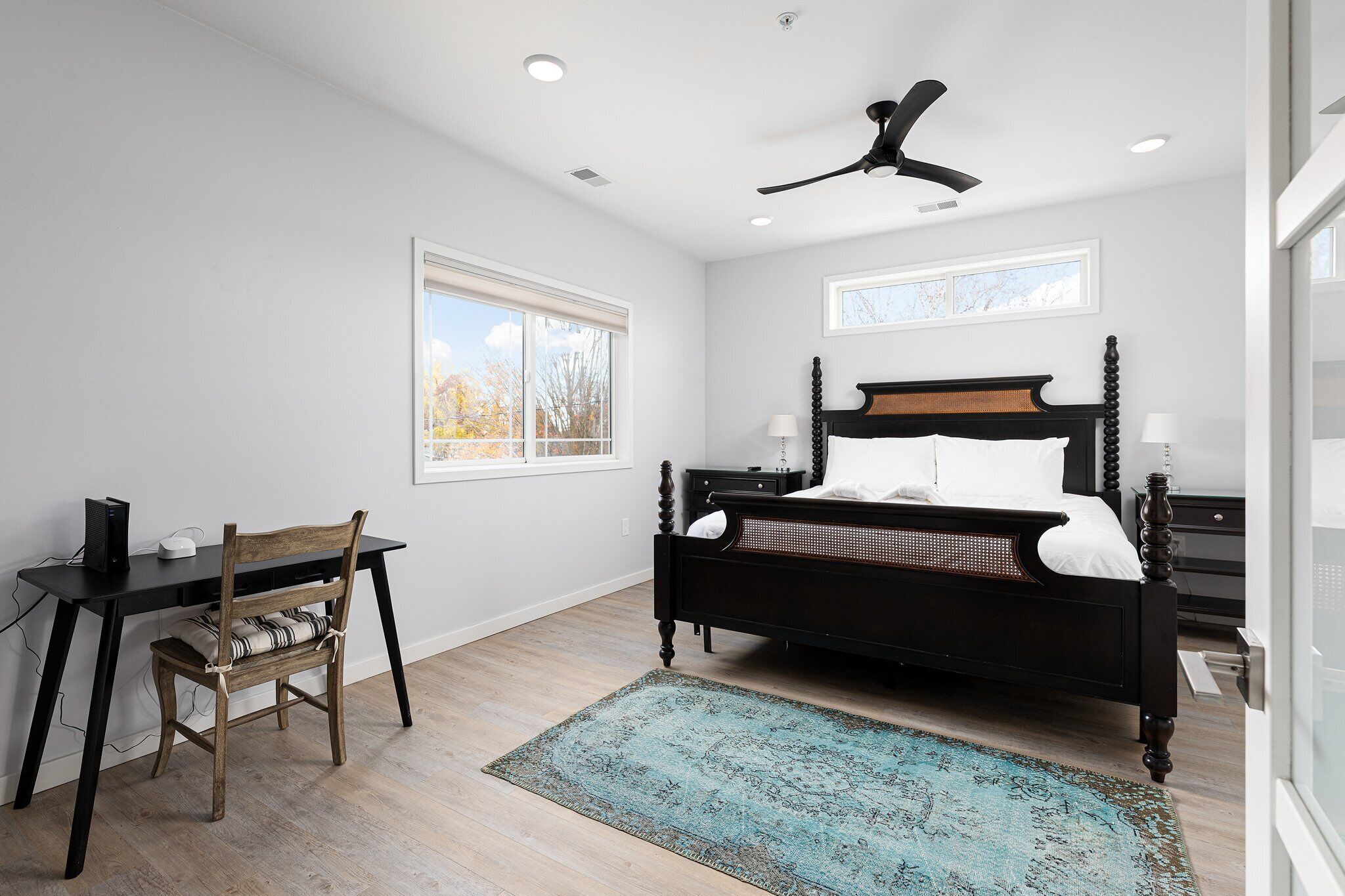 A bedroom with a bed, a desk, and a chair.