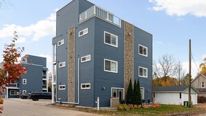A multi-story residential building with a blue exterior and a stone accent wall.