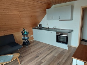 Una cocina compacta con horno integrado, un lavabo y una encimera.