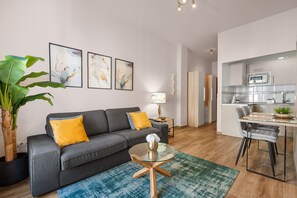 A modern living room with a sofa, coffee table, and artwork on the wall.