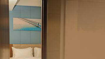 A bathroom with a bed, a mirror, a towel rack, and a sink.