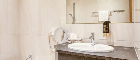 Un baño moderno con tocador de mármol, un bidé, un espejo grande y un calentador de toallas.