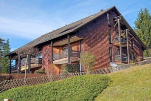 A modern wooden house with a sloped roof, multiple balconies, and a well-maintained garden. - Lotti Apartment with Mountain Views, Balcony, and Wi-Fi (Titisee-Neustadt)