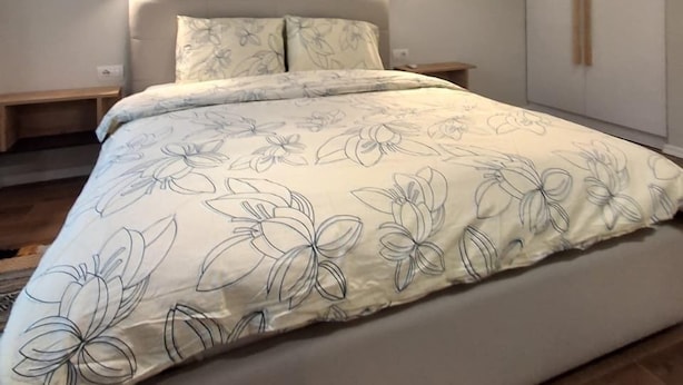 A modern bedroom with a bed, bedside tables, and a wardrobe. - AR Hotel (Tirana)