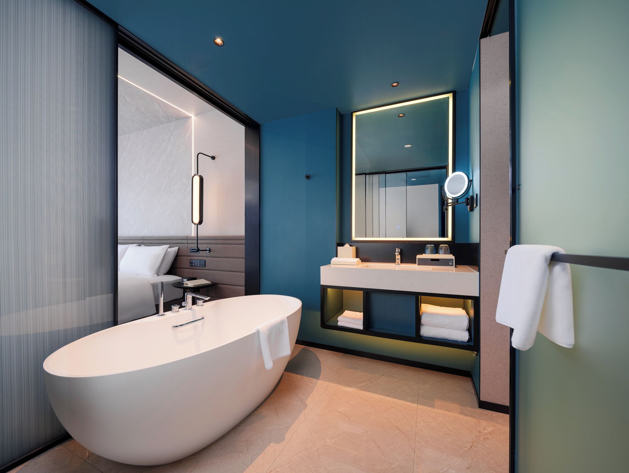 A modern bathroom with a freestanding bathtub, a vanity with a mirror, and a towel rack.