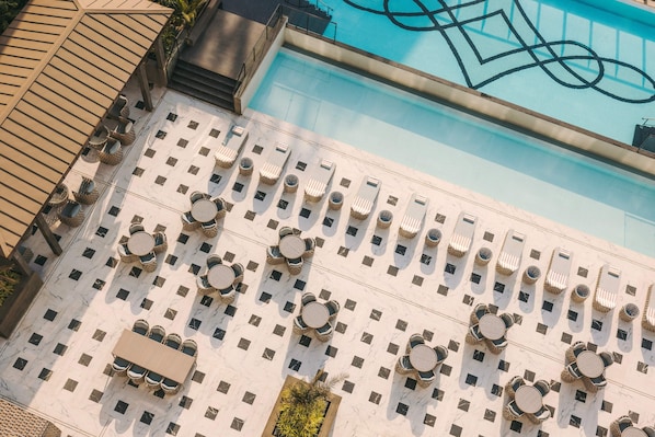 Una piscina al aire libre, sombrillas, tumbonas