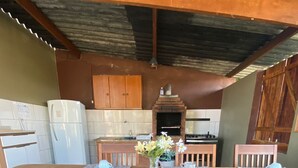 A rustic kitchen with a wooden table set for four, surrounded by wooden chairs. - Romantic chalet for couples in love. (Santa Isabel)