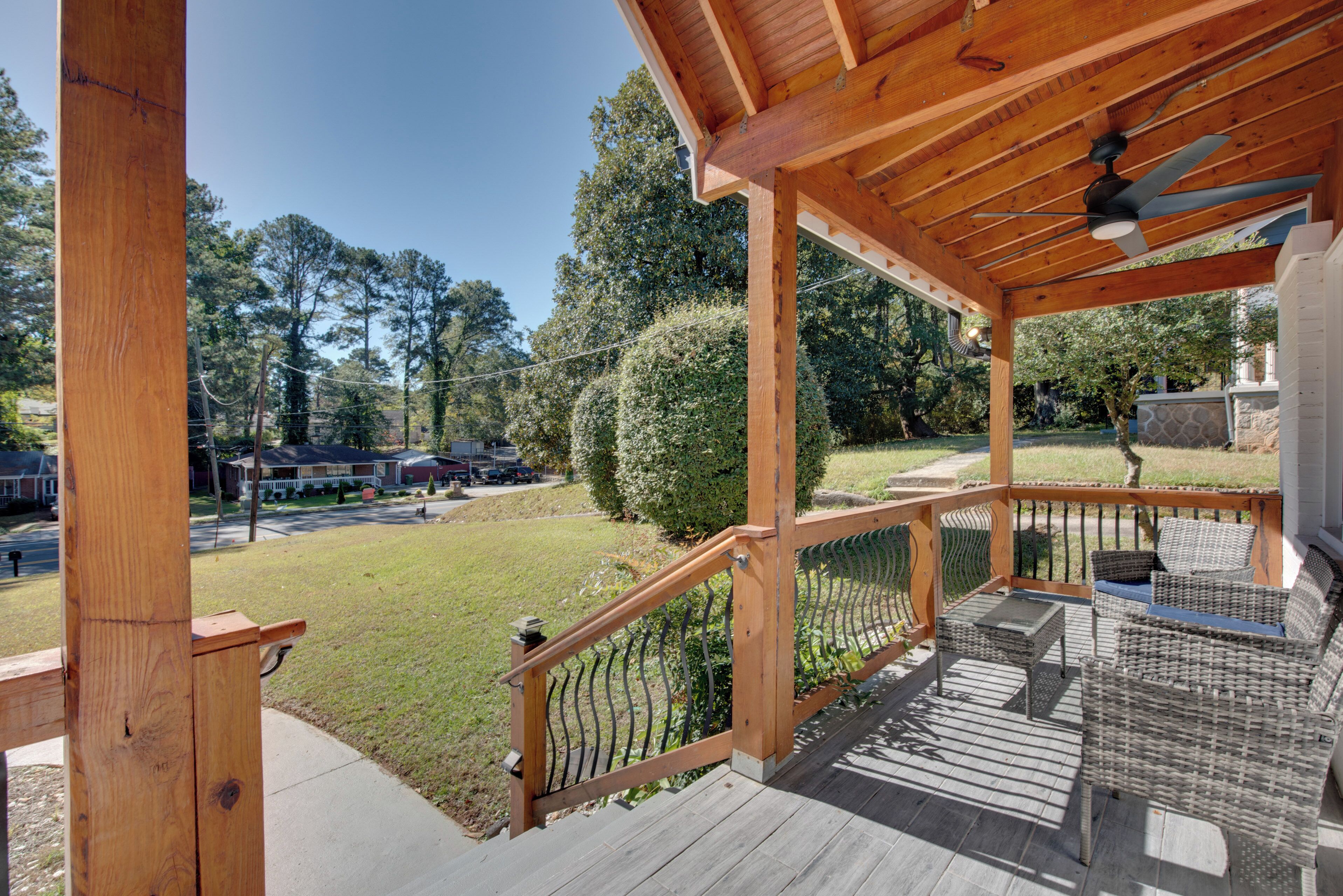 A wooden deck with outdoor furniture and a view of a residential area.