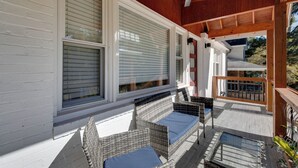 Eine überdachte Veranda mit Korbmöbeln und Deckenventilator.
