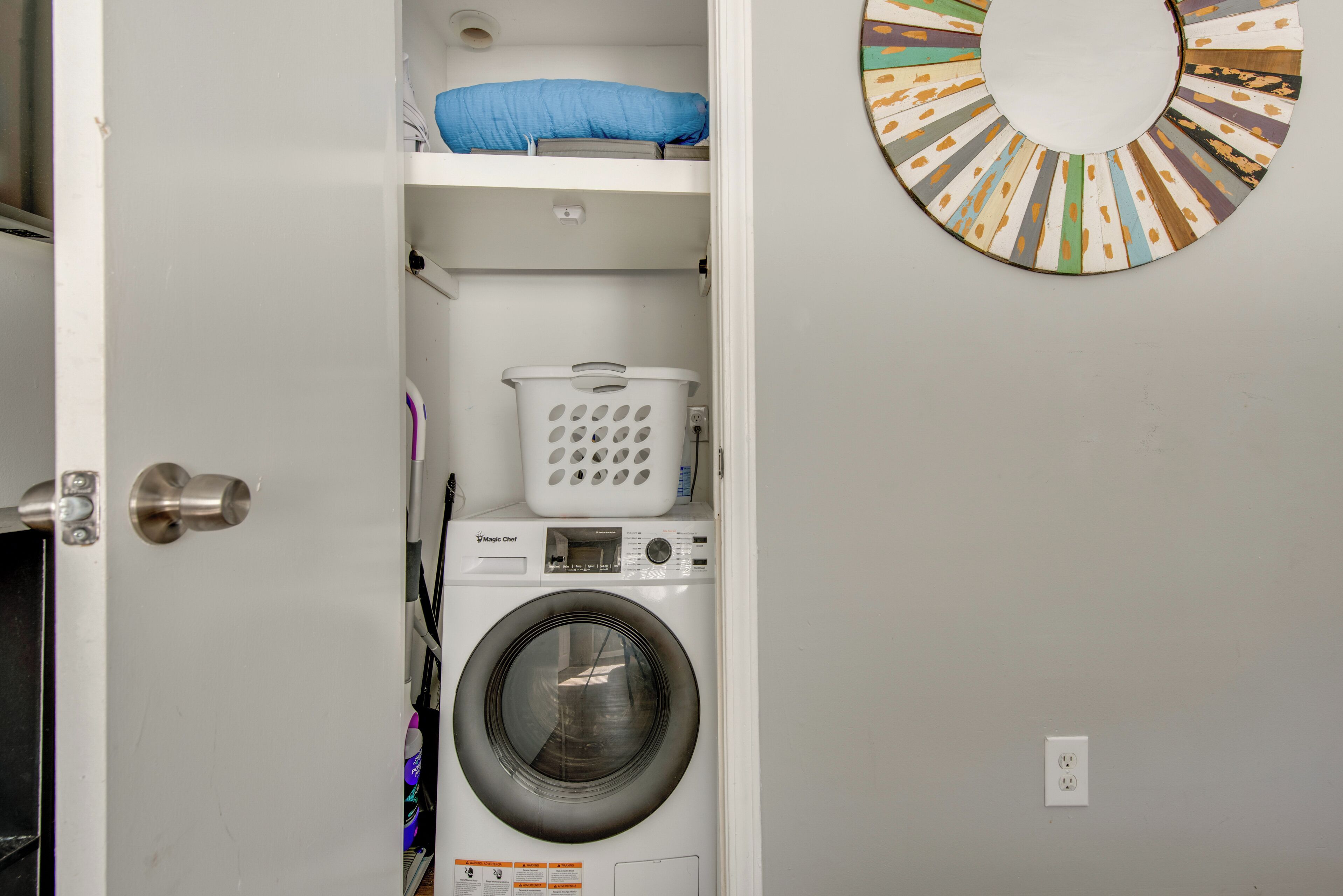 A laundry room with a washing machine, a dryer, and a laundry basket.