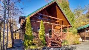 A log cabin with a porch, a staircase, and a small garden area. - Log Cabin, Private Hot Tub, Mtn View, Near Dtwn (Gatlinburg)