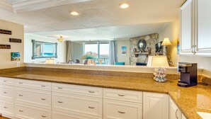A kitchen with granite countertops, white cabinetry, and a coffee maker. - Direct Sand Access! Family Pensacola Beach Retreat (Pensacola Beach)