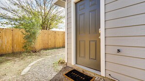 A house with a front door, a wooden fence, and a small tree. - Walk to Park: Dog-friendly Retreat in Pflugerville (Pflugerville)