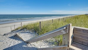 A beach with a wooden fence and a wooden bench. - Oceanfront Retreat in Flagler Beach! Bright Apt (Flagler Beach)