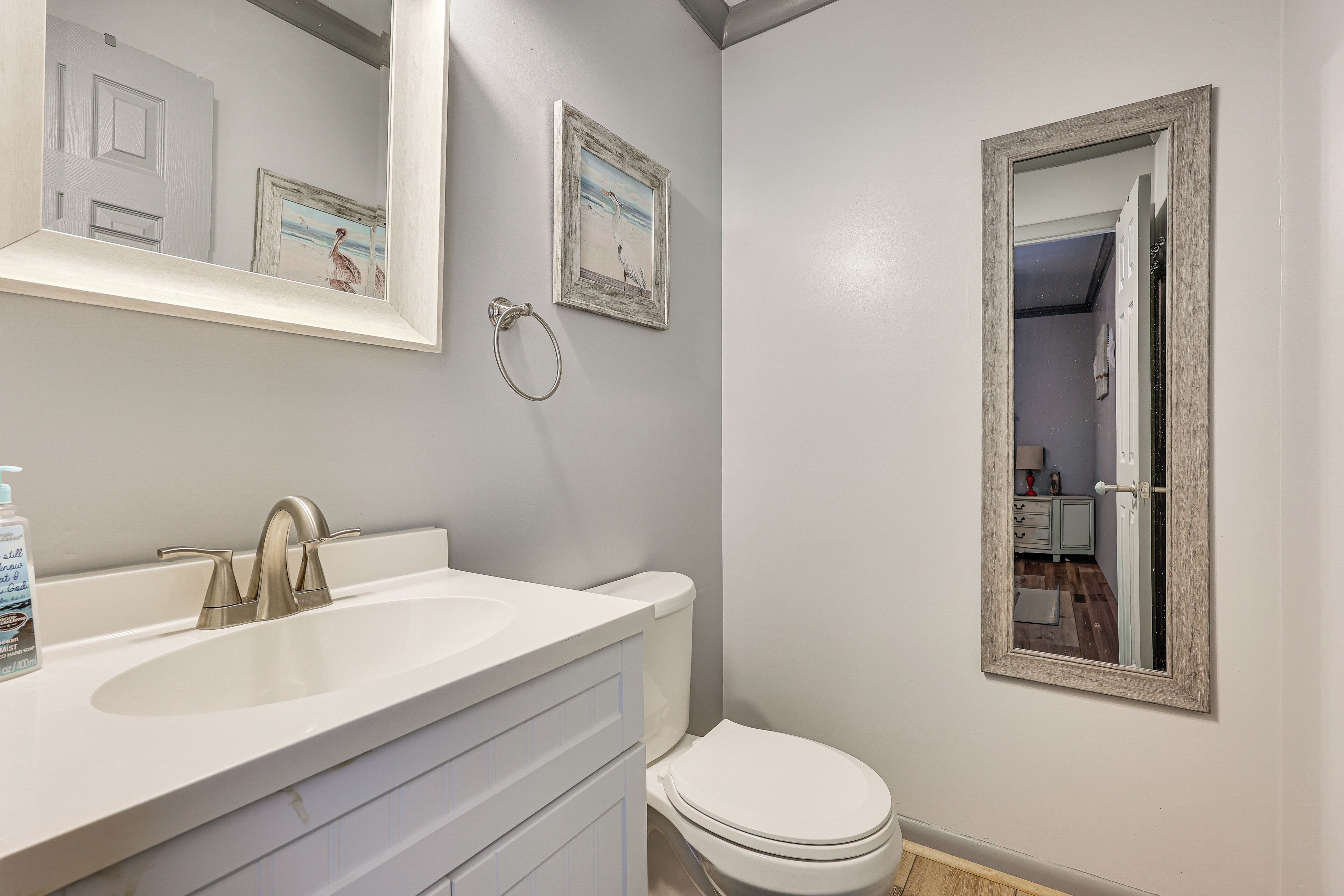 A bathroom with a white sink, a toilet, and a mirror.