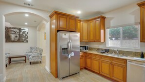 A kitchen with wooden cabinets, a stainless steel refrigerator, a microwave, and a sink. - Explore the OC Coast! Midway City Home w/ Yard (Midway City)