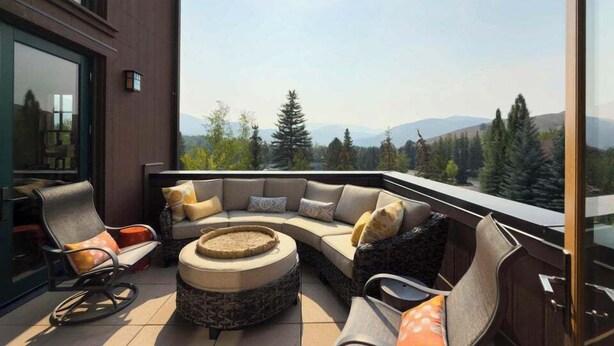 A modern outdoor seating area with a curved sofa and chairs, a round coffee table, and a view of a mountainous landscape. - Elkhorn Springs 15 - Luxury w/ Great Views, Walk to Pool, Tennis, Golf (Elkhorn)