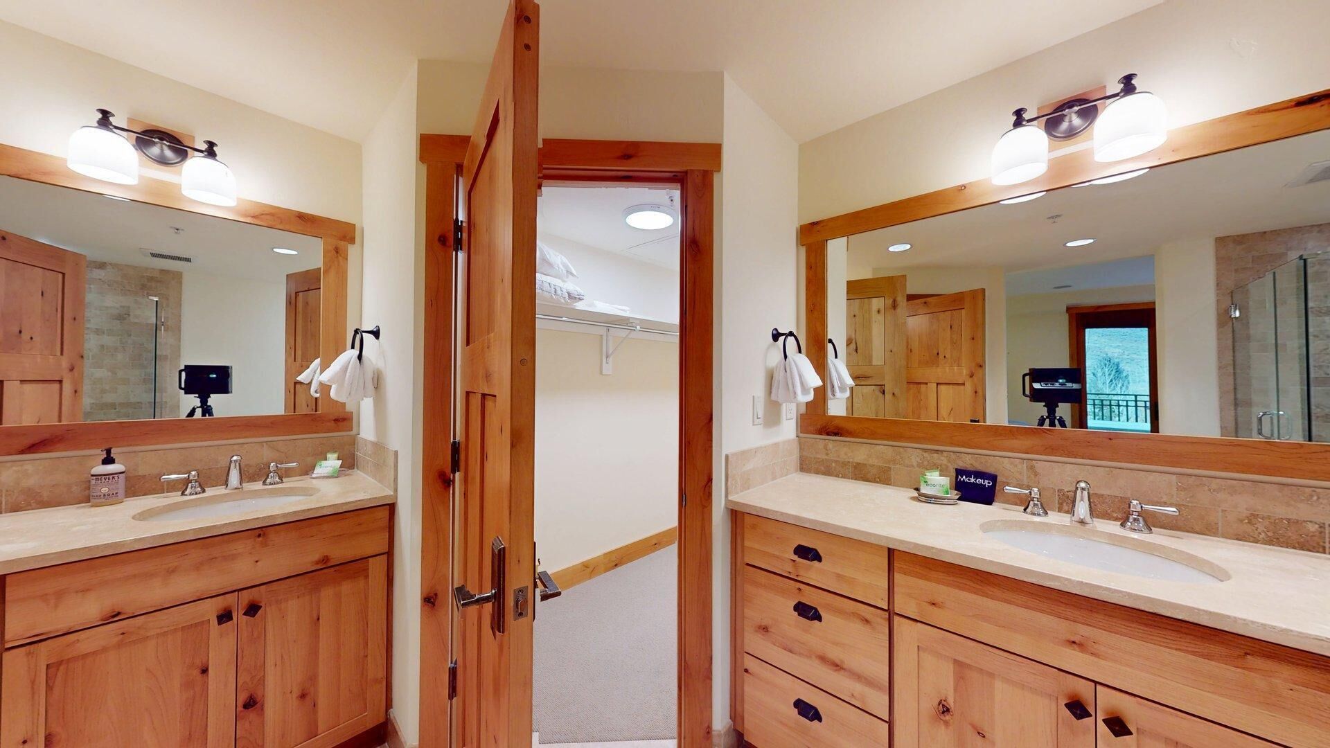 A bathroom with wooden cabinets, two sinks, and large mirrors.