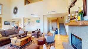 A spacious living room with a fireplace, leather furniture, and a staircase leading to an upper level. - Elkhorn Springs 15 - Luxury w/ Great Views, Walk to Pool, Tennis, Golf (Elkhorn)