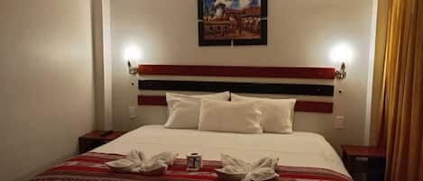 A hotel room with a bed, a painting on the wall, and a window with curtains.