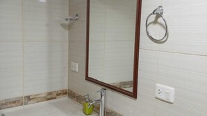 A bathroom with a white sink, a mirror, and a towel ring. - Raymi MachuPicchu (Aguas Calientes)