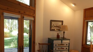 Un dormitorio con cama, una silla, un tocador y una ventana.