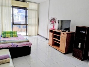A bedroom with a bed, a TV, a fan, and a wardrobe. - Room-jr-house 34-103 Near Donmuang Airpo (Bangkok)