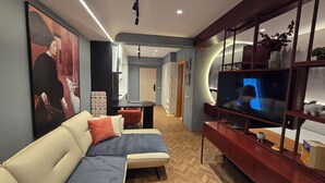 Een moderne woonkamer met een bank, een televisie en een decoratieve plank.