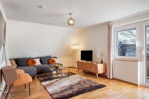 Ein modernes Wohnzimmer mit Sofa, Couchtisch und TV-Schrank.