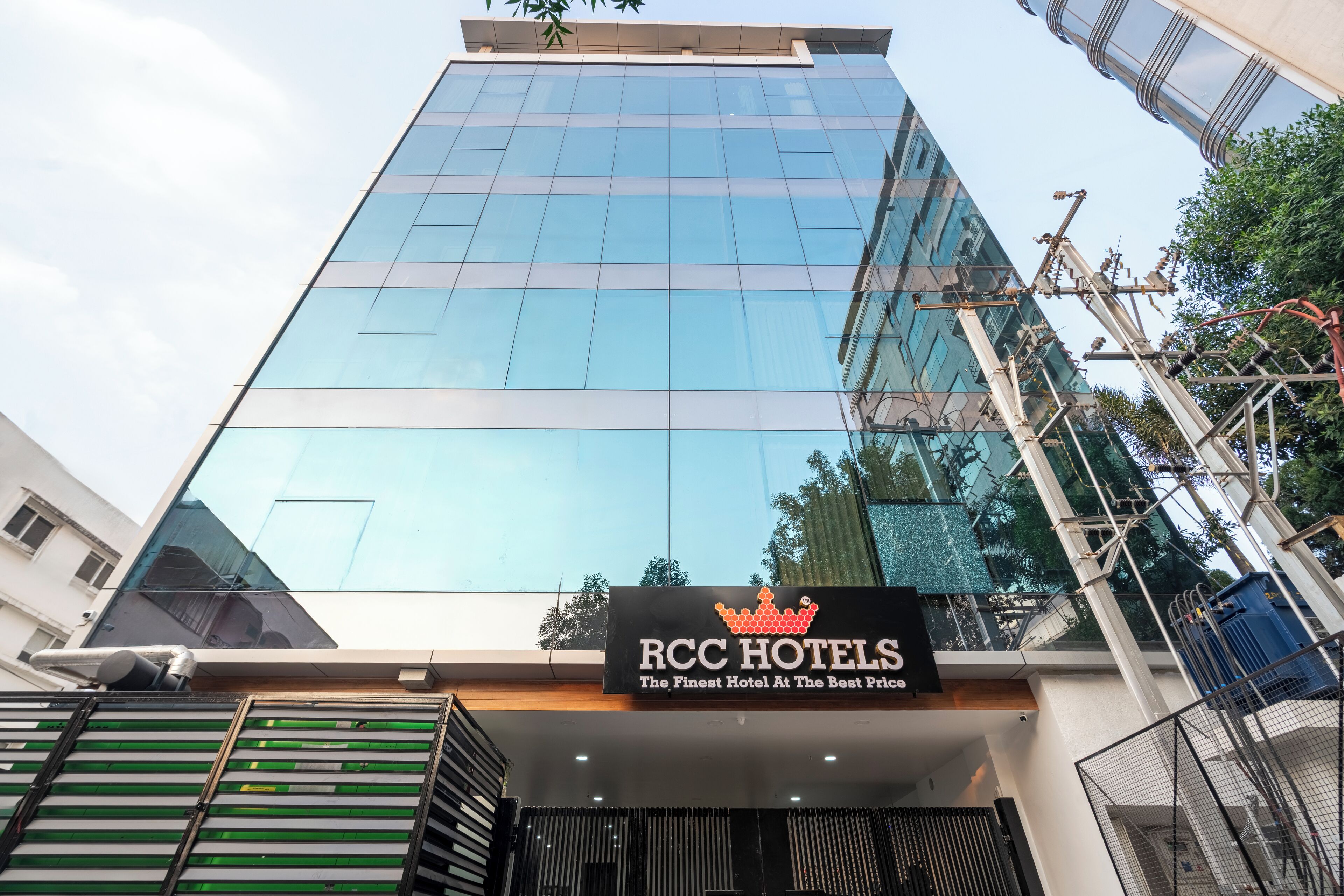 En modern hotellbyggnad med en fasad av glas och en skylt med texten ”RCC Hotels”.