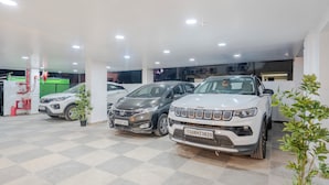A car dealership with multiple cars on display, including a white Jeep and a silver Honda. - RCC Gachibowli (Hyderabad)